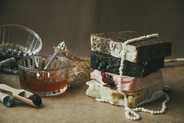 A stack of rustic handmade soap bars with natural ingredients and honey in a cozy setting.