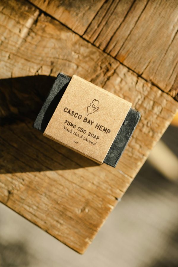 High-quality handcrafted CBD soap with vanilla oak scent on a wooden surface.